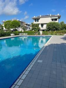 una grande piscina blu con un edificio sullo sfondo di Villa a due piani con giardino e piscina a Duna Verde