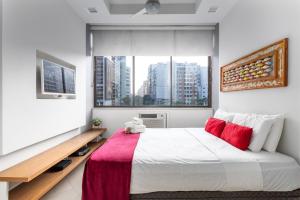 1 dormitorio con 1 cama blanca grande con almohadas rojas en Aconchego em Copacabana - 150m da praia - PI401 Z5, en Río de Janeiro