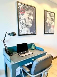 a desk with a laptop computer on top of it at Red Rock Apartments - mit Parkplatz, Küche und Netflix in Trier