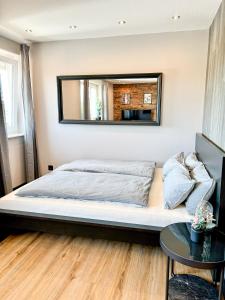 a bedroom with a bed and a mirror on the wall at Red Rock Apartments - mit Parkplatz, Küche und Netflix in Trier