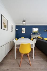 comedor con mesa blanca y sillas amarillas en Spacious 5-bedroom home perfect for large groups en Polesworth