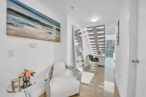 a white living room with a white chair and a table at Modern 2 Story Loft 2BR with Breathtaking Views in Miami