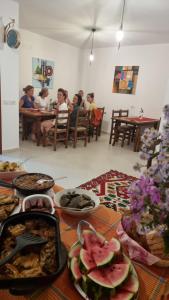 un grupo de personas sentadas en una mesa con comida en Kalaja Inn en Krujë