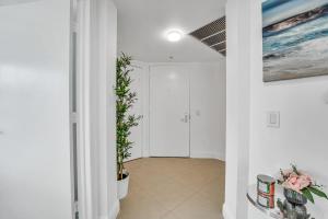 un pasillo con paredes blancas y una pintura en la pared en Modern 2 Story Loft 2BR with Breathtaking Views, en Miami