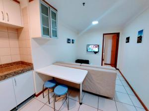 a room with a bed and a table and two stools at Nobile Flat Particular G07 in Brasilia