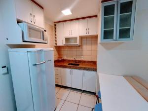 a kitchen with white cabinets and a refrigerator at Nobile Flat Particular G07 in Brasilia