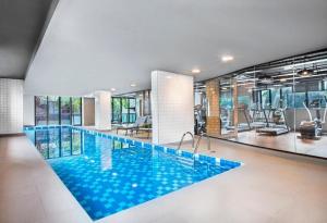 a large swimming pool with blue water in a building at Flat International Business Ibirapuera, 2534 Moema in São Paulo