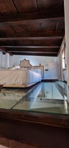 a glass floor in a bedroom with a bed at ADANAR-Apartamentos Muralla Zirí in Granada