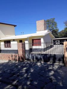 una casa con una valla delante de ella en Casa de Huerta en Huerta Grande