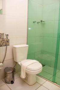 a bathroom with a toilet and a glass shower at Domus Hotel Trindade Canaã dos Carajás in Canaã dos Carajás