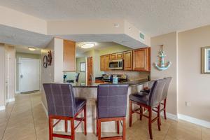 a kitchen with a bar and chairs in a room at Sand and Sea Enjoyment Retreat in Ormond Beach