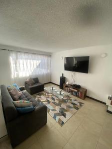 uma sala de estar com um sofá e uma televisão de ecrã plano em Hostel Urban City Bogotá em Bogotá