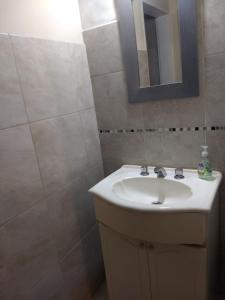 a bathroom with a sink and a mirror at departamento Euge in Olavarría