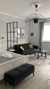 una camera con letto e un soggiorno con divano di Modernes Apt mit direkter Anbindung zur City und Messe ad Hannover