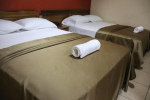 two beds in a hotel room with towels on them at Hotel Residencial Panamericano in David