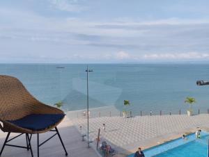 een stoel naast een zwembad naast de oceaan bij Punta Blanca Beach Apartments Manta Coliving Ecuador in Jaramijó