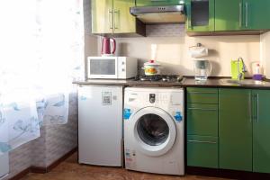 eine Küche mit einer Waschmaschine und einer Mikrowelle in der Unterkunft Паттайя in Petropawlowsk