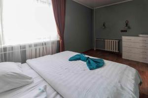 ein Schlafzimmer mit einem weißen Bett mit blauem Bogen in der Unterkunft Паттайя in Petropawlowsk