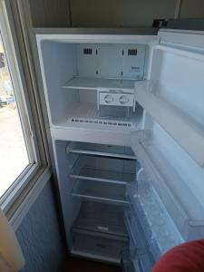 an empty refrigerator with its door open at Hospedaje depto 2 habitaciones in Coronel