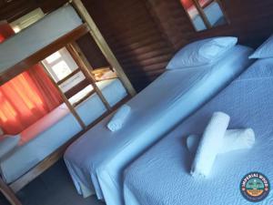 2 camas individuales en una cabaña con ventana en HOTEL IMPERIAL WOOD en Capurganá