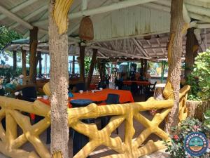 restauracja z drewnianym płotem i stołami w obiekcie HOTEL IMPERIAL WOOD w mieście Capurganá