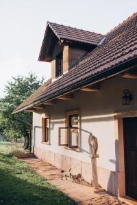 a house with two cats walking outside of it at Stodola na vršku in Jičín