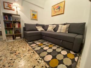 a living room with a gray couch and a rug at TumHouse (la capanna di zio Tom) in Ceglie Messapica