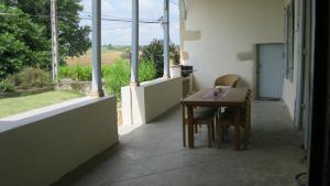 Zimmer mit einem Tisch, Stühlen und einem Fenster in der Unterkunft La Metairie des Ducs in Sainte-Colombe-de-Duras