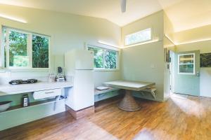 eine Küche mit einem Tisch in der Mitte eines Zimmers in der Unterkunft PonoMana Oasis's - Zen Cottage in Captain Cook