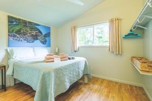 ein Schlafzimmer mit einem Bett mit Handtüchern darauf in der Unterkunft PonoMana Oasis's - Zen Cottage in Captain Cook + 56 Fotos