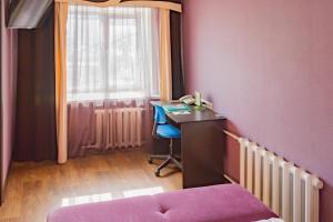 a bedroom with a desk and a chair and a window at Петербург in Petropavlovsk
