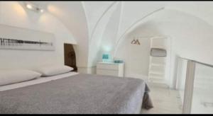 Dormitorio blanco con cama y estante blanco en Maestrale Holiday Home, en Brindisi