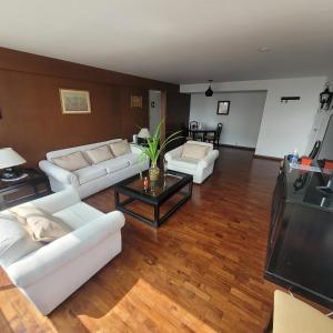 a living room with white couches and a television at The Guest House 1 at the booming center of Miraflores, Lima - Peru in Lima