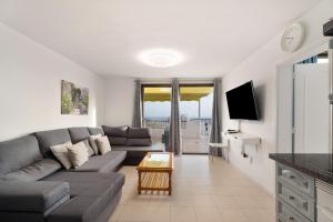 a living room with a couch and a tv at Penthause Luxe 501 sea View pool in Playa Fañabe