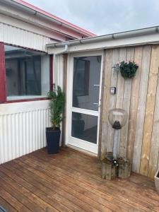 a wooden deck with a sliding glass door on a house at Luxus apartment Byggdarhorn in Selfoss