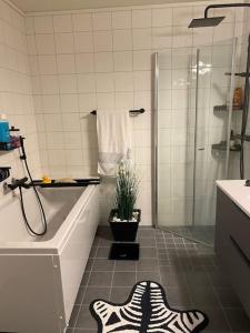 baño con bañera, ducha y planta en Charming apartment in Meråker en Meråker