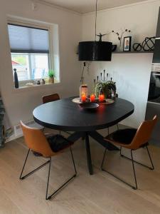 uma mesa de jantar preta com cadeiras e velas em Charming apartment in Meråker em Meråker