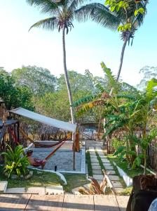 a hammock in front of a pool with palm trees at DuMangue Kite House in Guriú