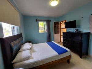 a bedroom with a bed and a dresser and a television at Habitación Cozumel in Cozumel