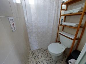a small bathroom with a toilet and a shower at Habitación Cozumel in Cozumel