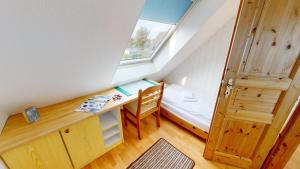 グレーミッツにあるSonnenhügel App. 08のデスク、ベッド、窓が備わる小さな客室です。