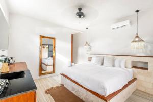 a white bedroom with a large bed and a mirror at Old Listing - Selva 5 in Tulum +31 photos