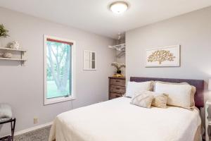a bedroom with a white bed and a window at Apple Cottage 