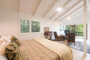 a bedroom with a large bed and a dining room at Craicor Boutique Apartments in Paihia
