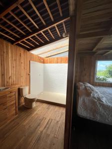 a bedroom with a bed and a bathroom with a window at La vida en el paraiso BORA BORA in Villavicencio