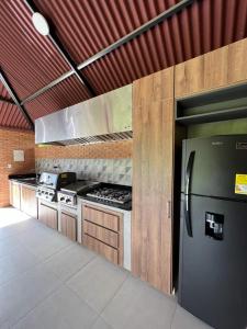 a kitchen with a stainless steel refrigerator and stove at La vida en el paraiso BORA BORA in Villavicencio