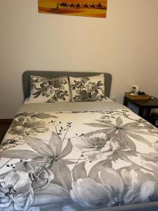 a bed with a floral bedspread on it at MAISON CHIC ET CALME in Étampes