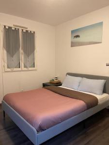 a bedroom with a bed and a window at MAISON CHIC ET CALME in Étampes