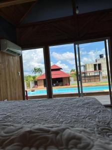 a bedroom with a bed and a view of a pool at La vida en el paraiso BORA BORA in Villavicencio