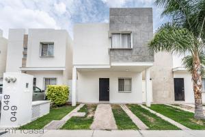 uma casa branca com uma palmeira em frente em Espaciosa Casa Moderna c/ Patio Privado em Aguascalientes